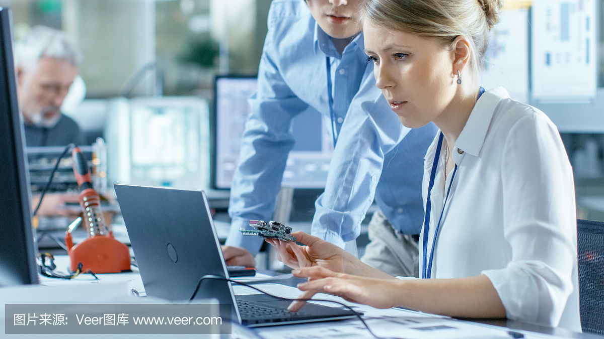 女計(jì)算機(jī)科學(xué)家將電路板連接到她的筆記本電腦并開始編程。她在先進(jìn)技術(shù)實(shí)驗(yàn)室工作。